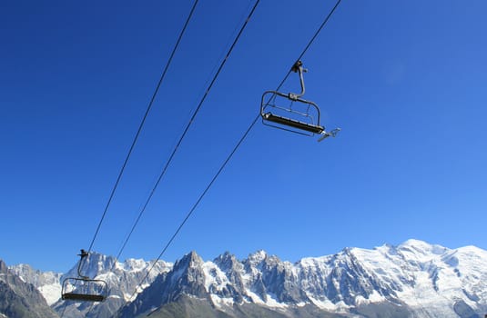 Two chair lifts and Mont-Blanc mountains behind, France, by very beautidul weather