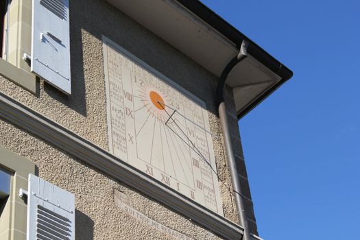 Solar clock on the wall of an old house by beautiful weather