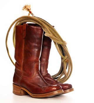 vertical image of a pair of brown cowboy boots and a Lasso on a white background 