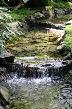 Water running among small waterfalls in a man-made stream.