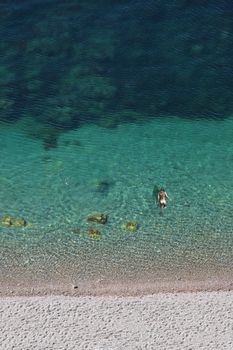 Nude woman swimming in turquoise water