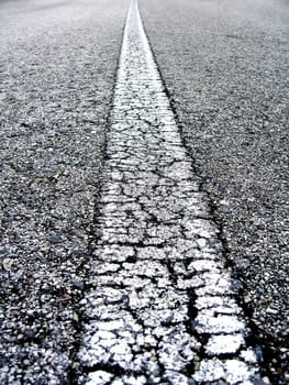 Close-up on the white line of an alphast road.