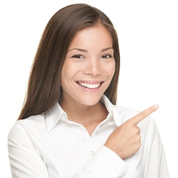 Woman pointing. Closeup portrait of young smiling woman pointing at copy space. Isolated on white background. Asian / Caucasian female model.