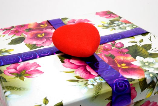 Red velvet heart lays on a gift box
