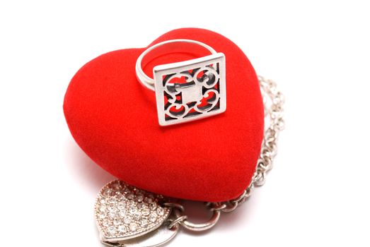 The silver ring lays on red velvet heart