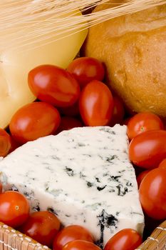 Slice of the Danish blue cheese with a mould among tomatoes.