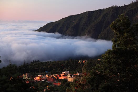 Tenerife - night scene showing the city Aguamansa in the valley of Orotava above the clouds.