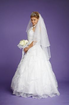 Young beautiful bride in a white dress on a purple background