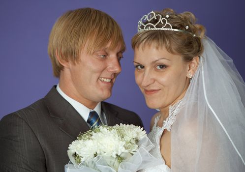 The bride and groom on a purple background closeup