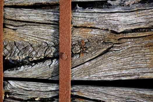 Closeup view of a old piece of wood wrapped with a rusty metal.