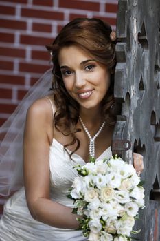 The beautiful bride with bouquet in park