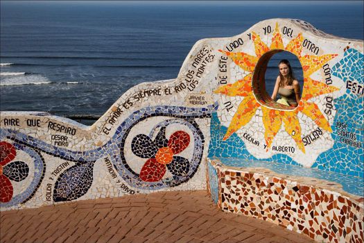 Portrait of the girl in a mosaic wall at coast of Pacific ocean. Peru.