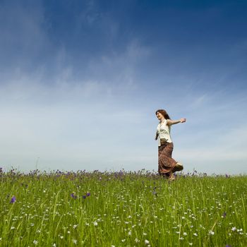 Young woman dancing on a beautiful green meadow