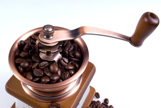 Clouse-up of ancient coffee grinder with coffee grains