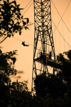 Silhoutte of tourists on zip line in Costa Rica