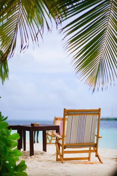 Relaxing on tropical paradise with white sand at Maldives and green palms with blue sky