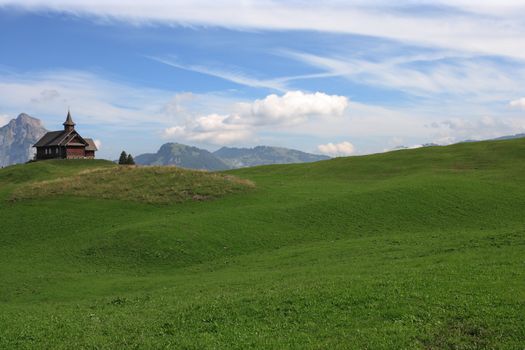 A church on a meadow in the alps of Switzerland. Taken on the hiking paths near Stoos.