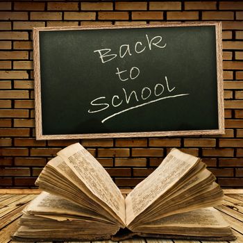 Photo of urban interior with school blackboard and opened vintage book 