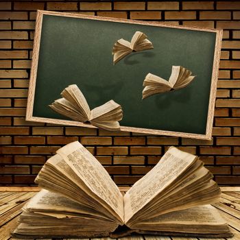 Photo of urban interior with school blackboard and opened vintage flying book 