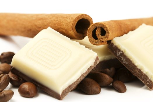 coffee chocolate, coffee beans and two cinnamon sticks on white background