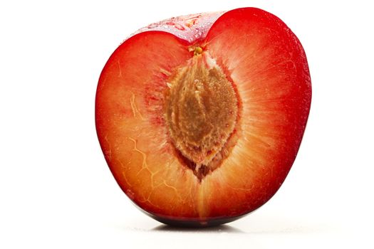 half wet plum with seed on white background