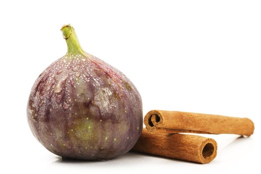 wet fig and cinnamon sticks on white background