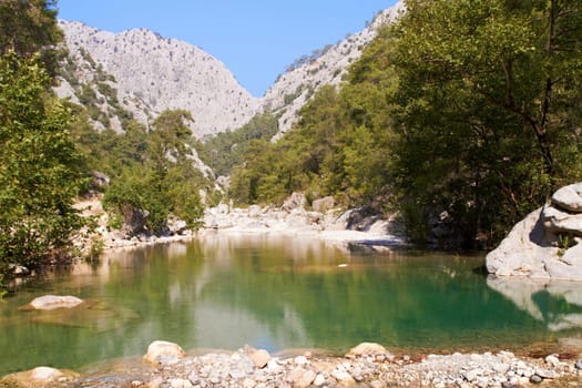 pond in the canyon of green mountains