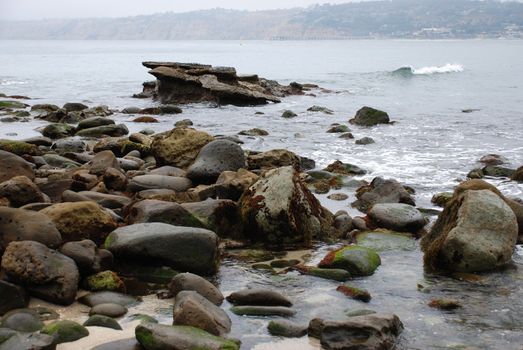 A group of rocks along the shoreline in La Jolla California
