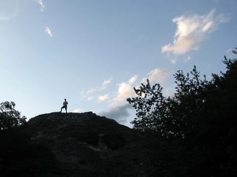 The sky, clouds, a rock, a stone, the person, a silhouette, people, trees, the nature, a landscape, a kind