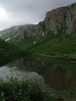 Mountains, rocks; a relief; a landscape; a hill; a panorama; Caucasus; top; lake, water, reflection, a slope; a snow