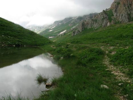 Mountains, rocks; a relief; a landscape; a hill; a panorama; Caucasus; top; lake, water, reflection, a slope; a snow
