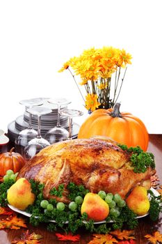Thanksgiving turkey dinner with fresh fruit, dishes and flowers.