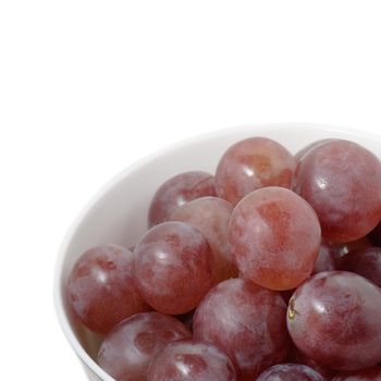 Fresh grapes in bowl with white copyspace.
