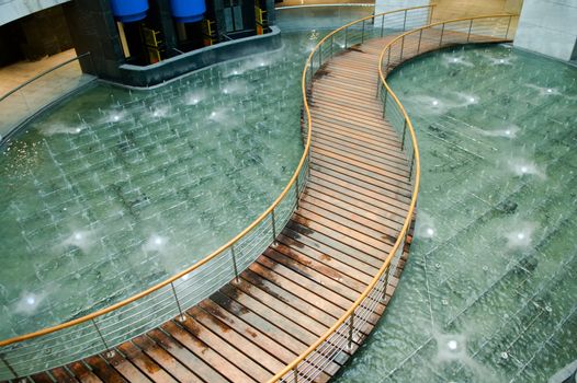 Curvy bridge over water pool