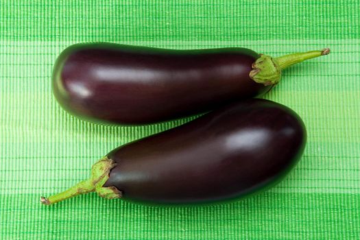 Two fresh eggplants on the green background