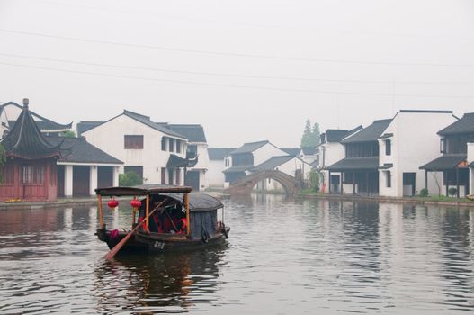The view of water town (Xi Tang) in China, with boat man rowing on river