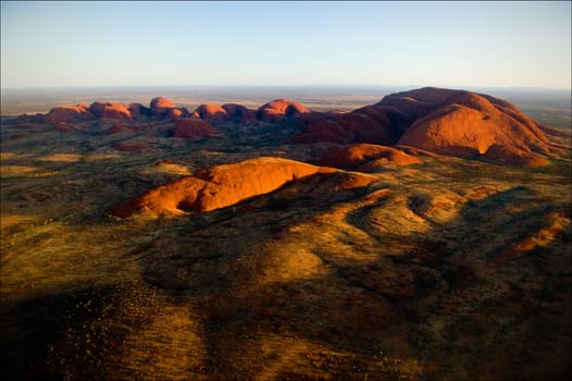 The highest monolith, Mount Olga in brightly red color of the coming sun.