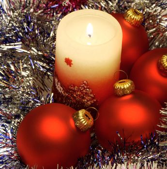 Christmas candle and red spheres. A celebratory composition