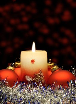 Christmas candle and red spheres. A celebratory composition