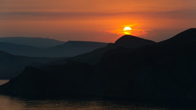 Colourful decline over mountains and the sea.