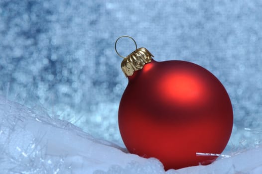 Christmas red sphere. Bokeh background blue toned