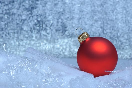 Christmas red sphere. Bokeh background blue toned