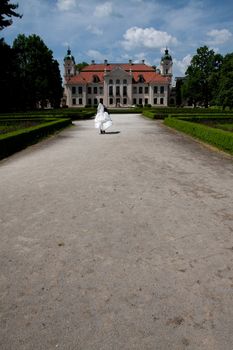 restaurated baroque palace in poland with garden and married couple running