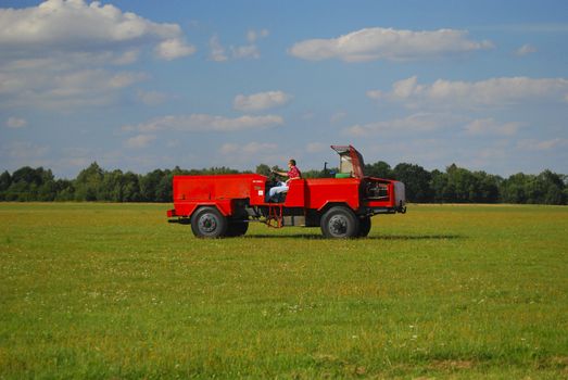 some old firetruck standing on grass with driver inside