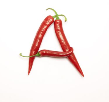 Letter made from red peppers over white backround