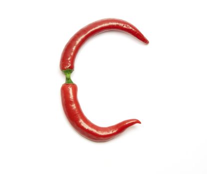 Letter made from red peppers over white backround