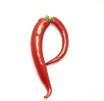 Letter made from red peppers over white backround