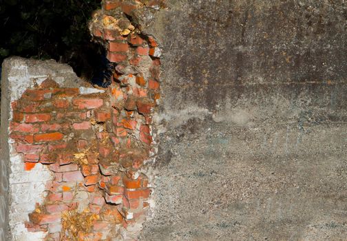 Dirty Concrete covered crumbling red brick wall