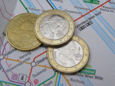 Euro coins over Vienna underground map