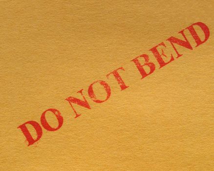 do not bend - red ink warning over a brown cardboard box